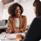 Businessperson laughs with client.